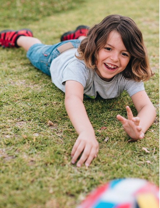 Child playing with a soccer ball on the grass at Montezuny Montessori microschool in Polk County, Florida, enjoying active early education.